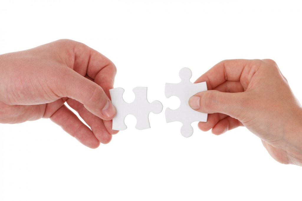hands connecting jigsaw pieces