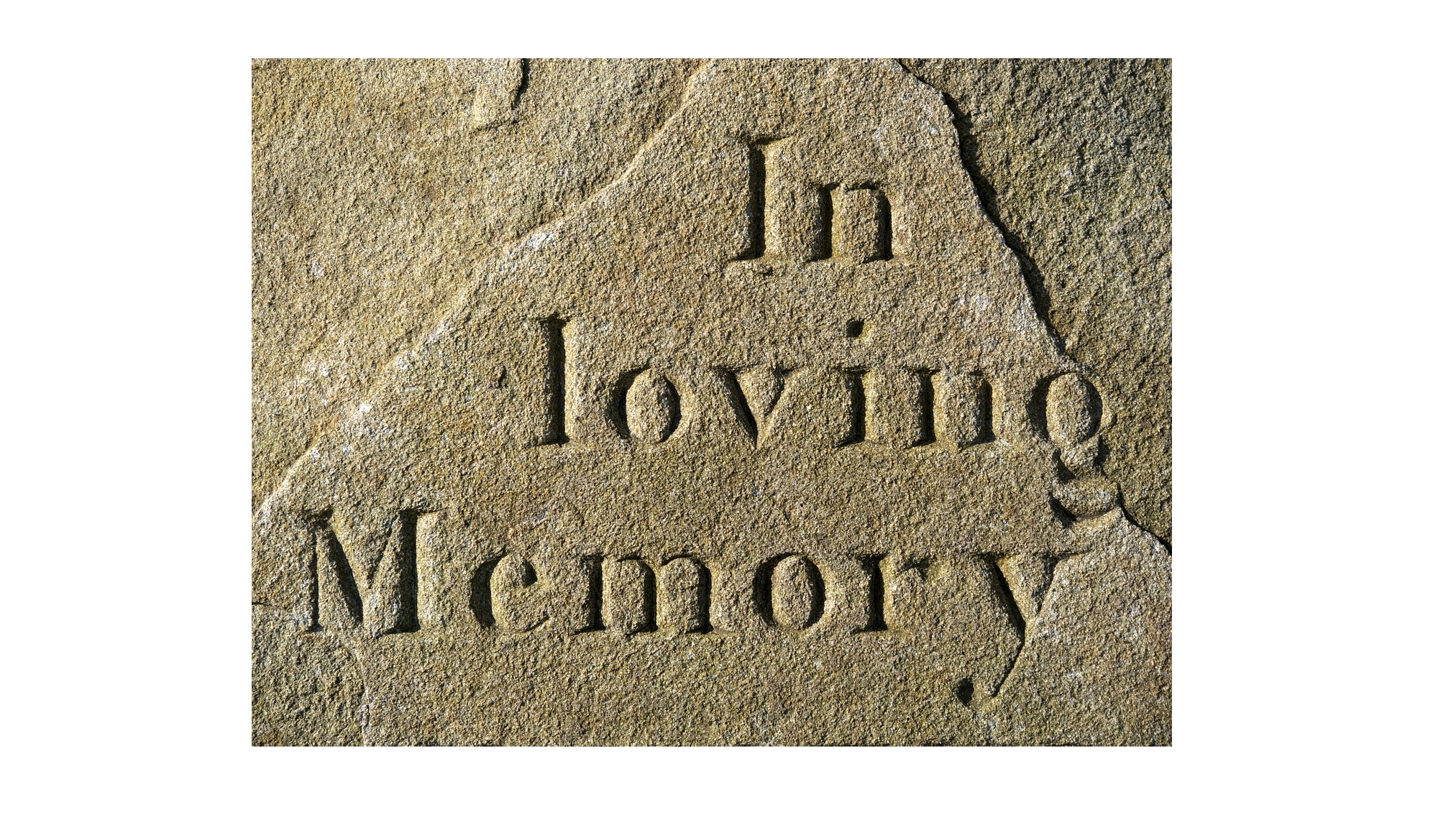 Closeup of a headstone which reads 'In Loving Memory'