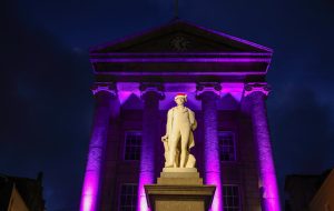 Humphry Davy Statue wearing a Christmas hat with the Market House lit up in the background