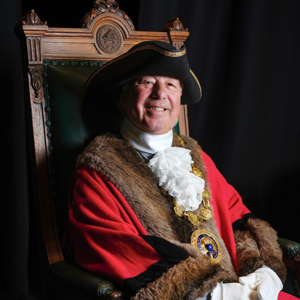 Mayor of Penzance Cllr Andy Law in full civic regalia sat on the Mayoral Chair